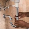Close-up Of Male Plumber's Hand Fixing Sink In Bathroom